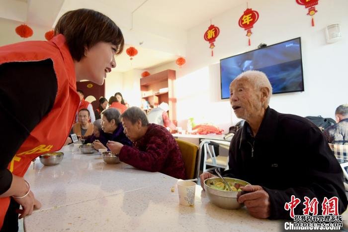 图为志愿者与老人交谈，送去温暖。　韦德占 摄